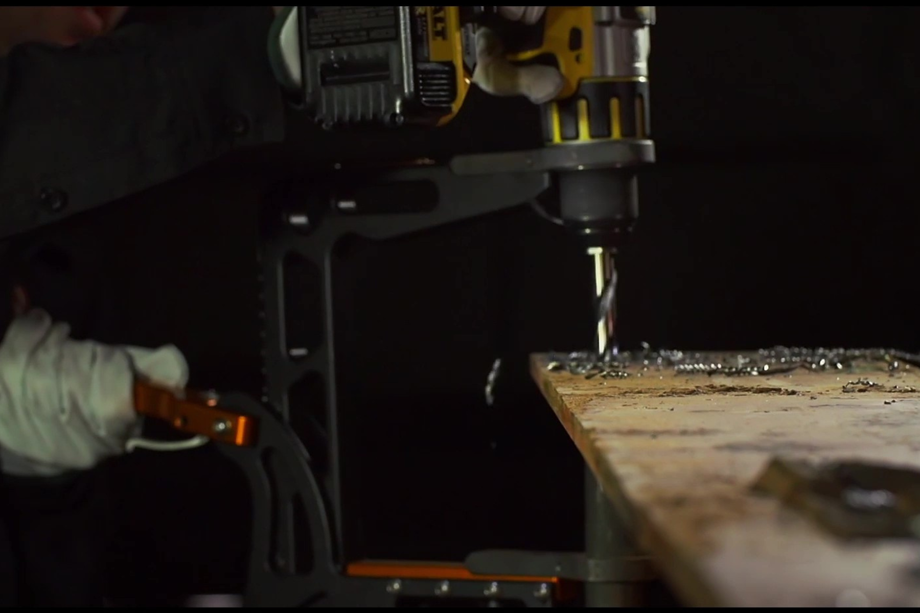 Close up of a worker using a dewalt and rapidrill combo to drill through metal I-beam